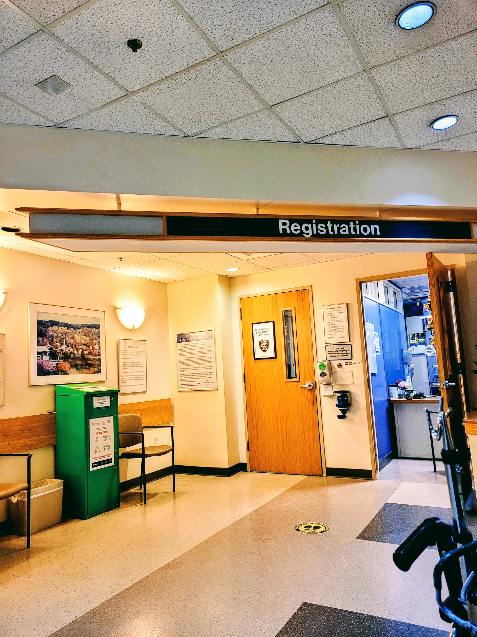 Androscoggin Valley Hospital lobby with registration sign, wooden door, green kiosk, and seating.