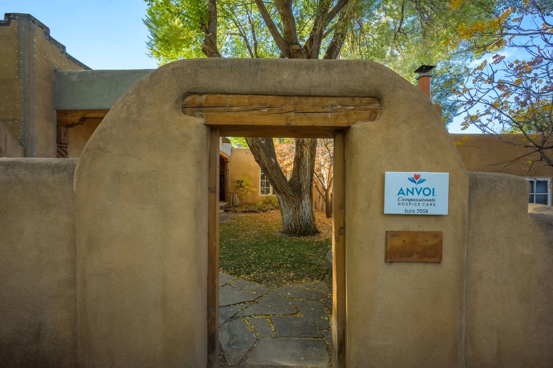 Adobe-style exterior entrance to Anvoi Hospice leading to a courtyard pathway