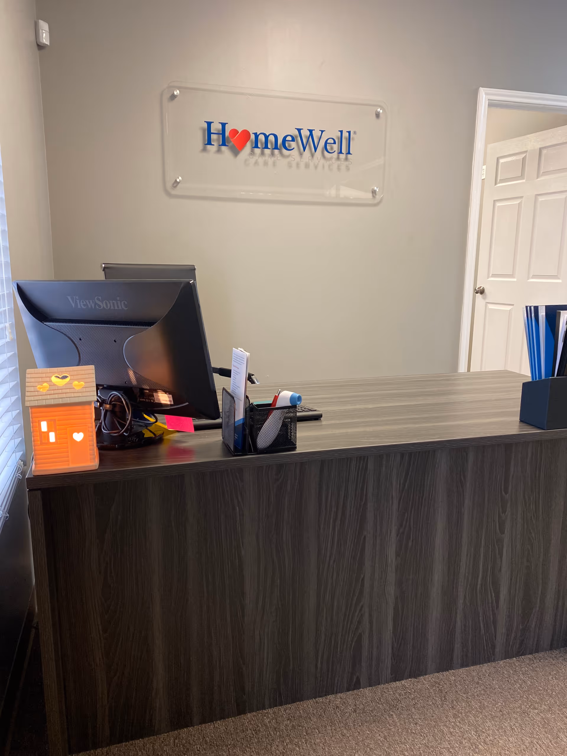 Reception desk in a HomeWell Care Services office with a computer monitor.