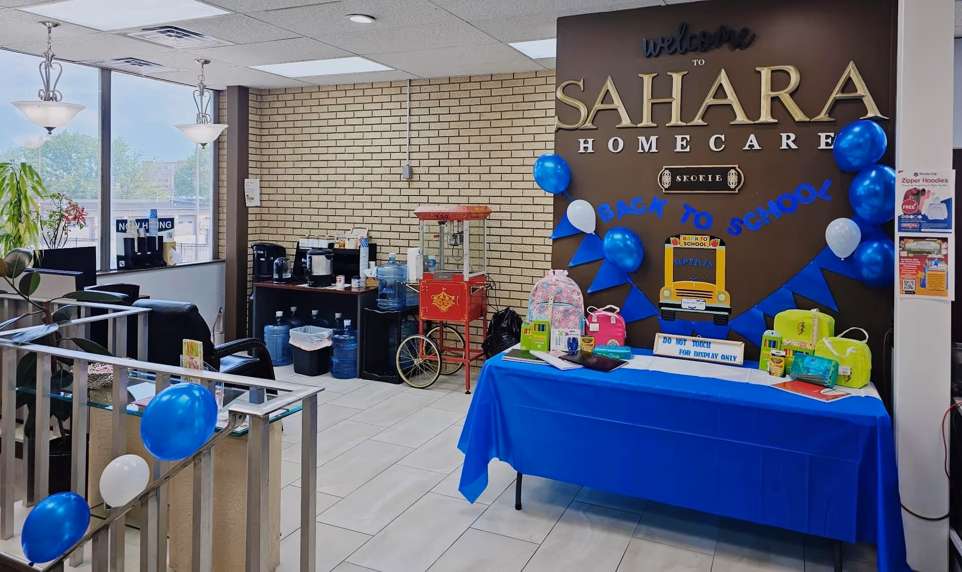 Interior reception area with Sahara Home Care sign, blue balloons, and a front desk table.