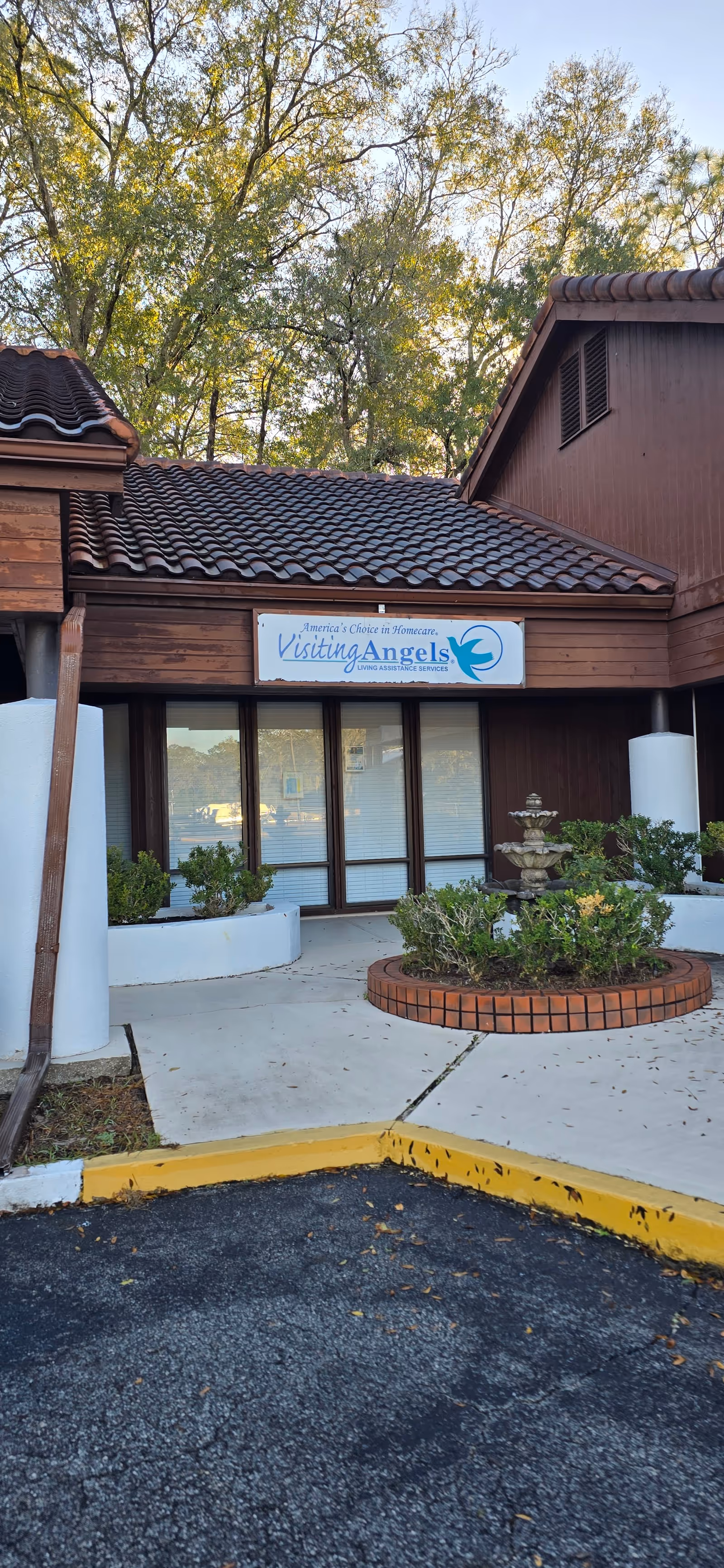 Exterior view of Visiting Angels entrance with sign, walkway, and landscaping.