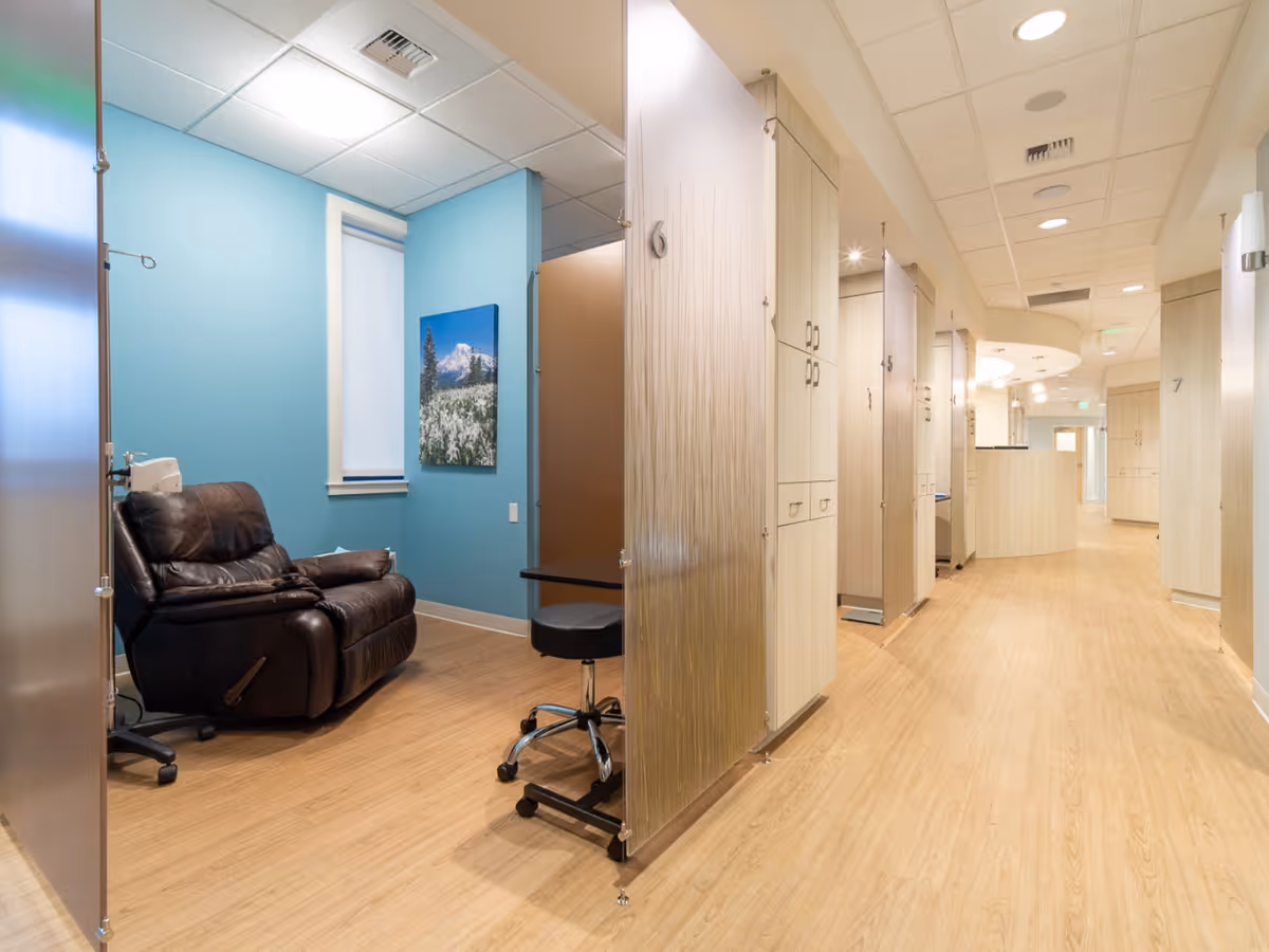 Bright interior hallway of a senior living facility with blue accent wall and seating.
