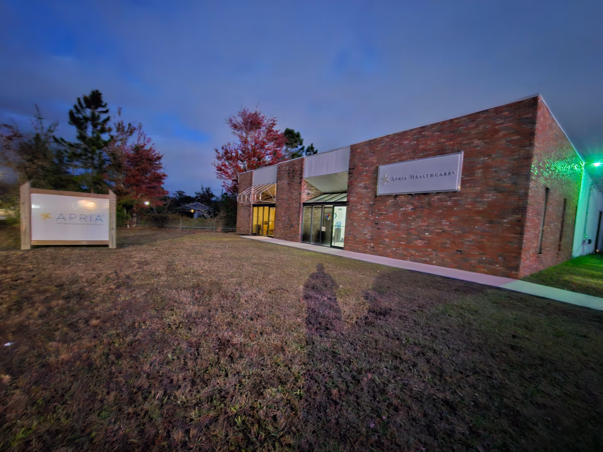 Exterior view of a brick Apria Healthcare facility with a grassy front yard.