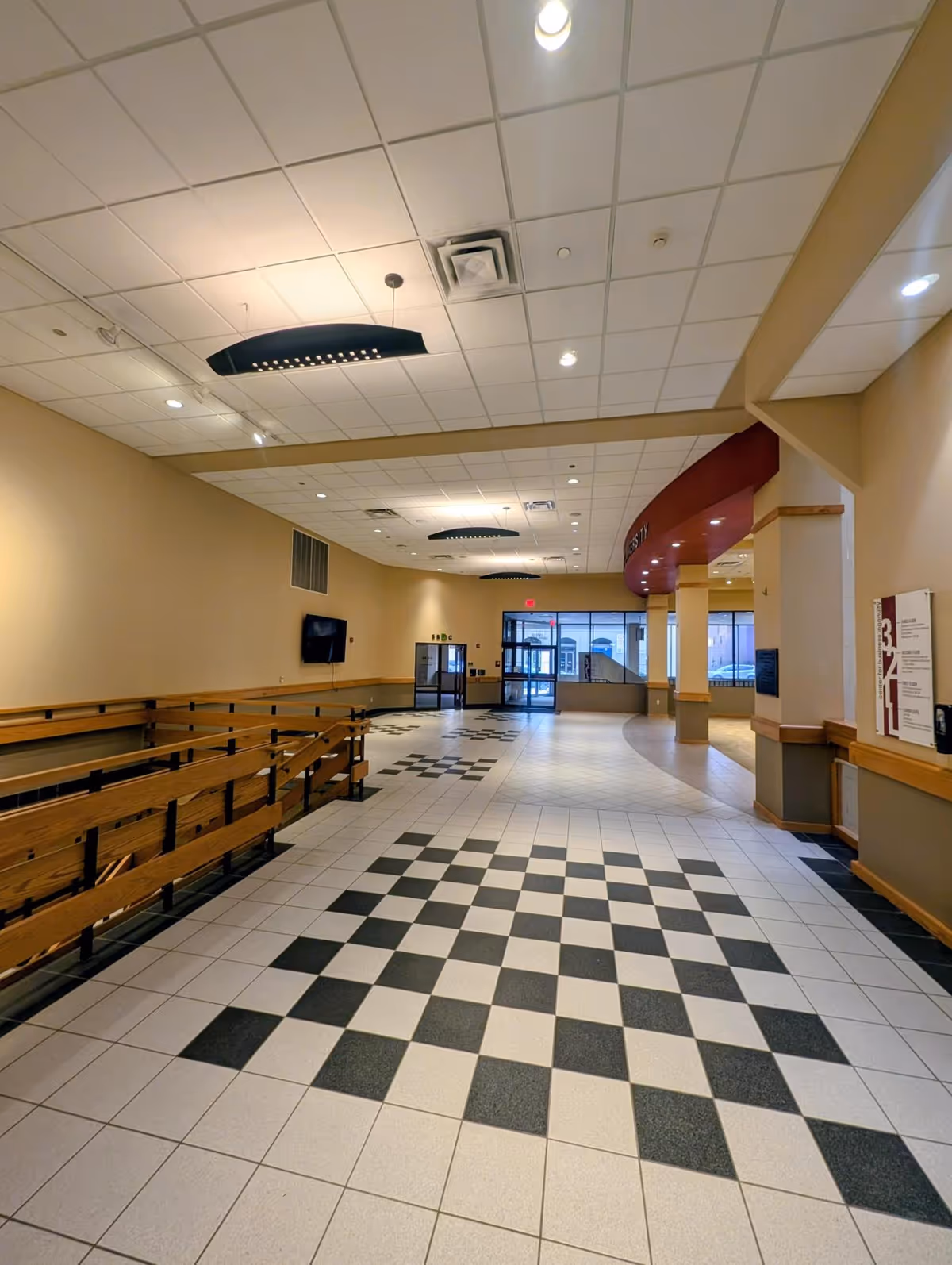 A wide hallway with tiled checkered floor inside a senior living facility.