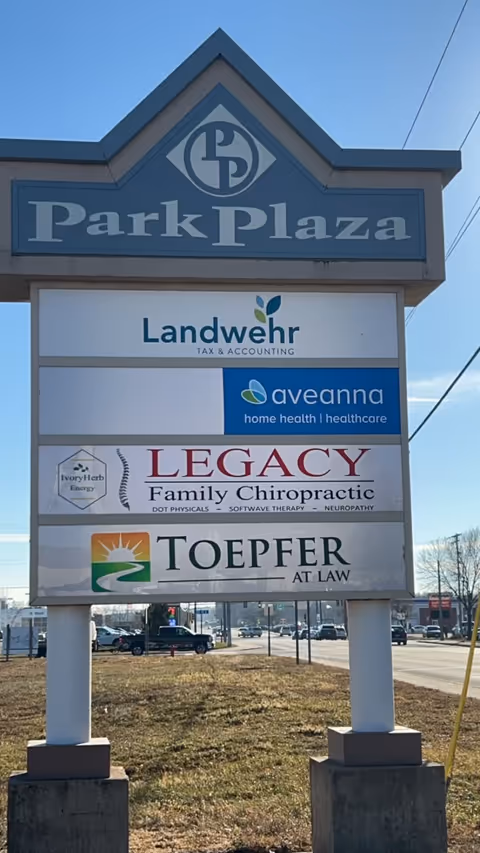 A tall outdoor signboard displays Aveanna Home Health among several businesses along the road.