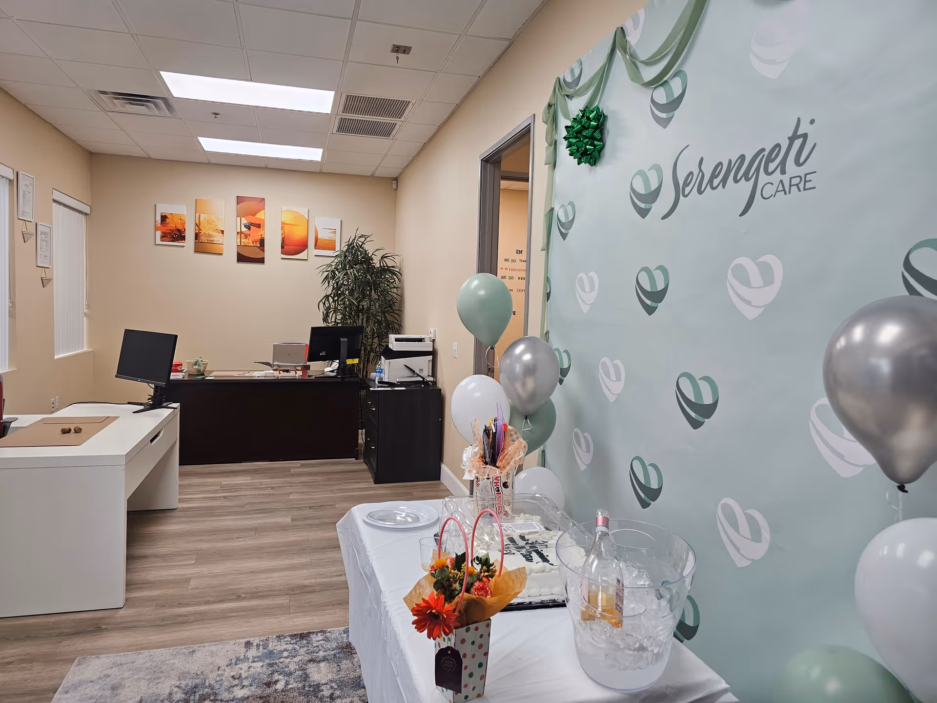 Reception area at Serengeti Care featuring a desk, balloons, a decorated table, and banner.