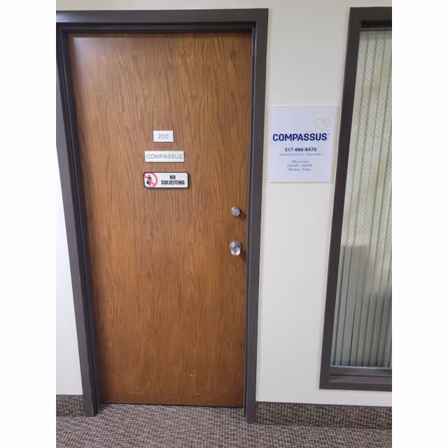 Wooden apartment door labeled 200 with a No Soliciting sign and Compassus plaque in the hallway.