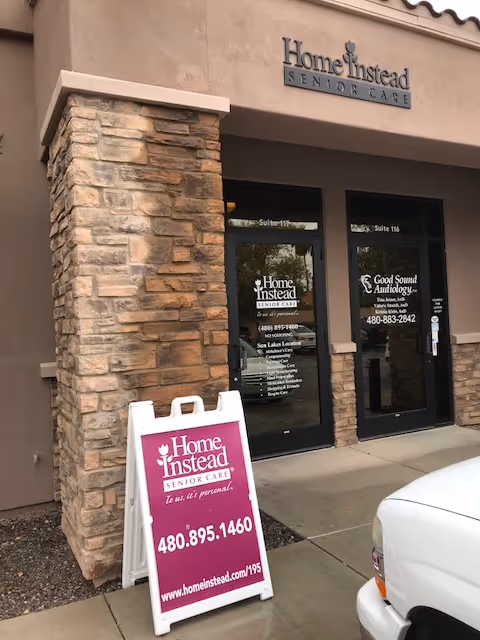 Front entrance of Home Instead Senior Care with stone pillars and a purple sign.