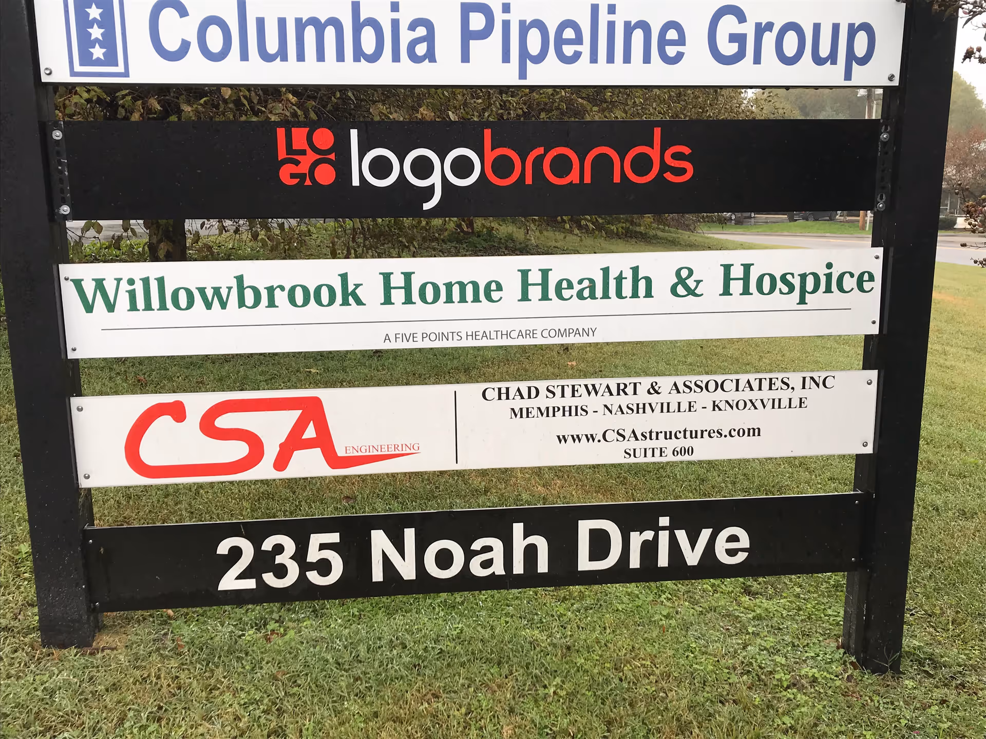 Outdoor signboard with Willowbrook Home Health & Hospice among various company signs.