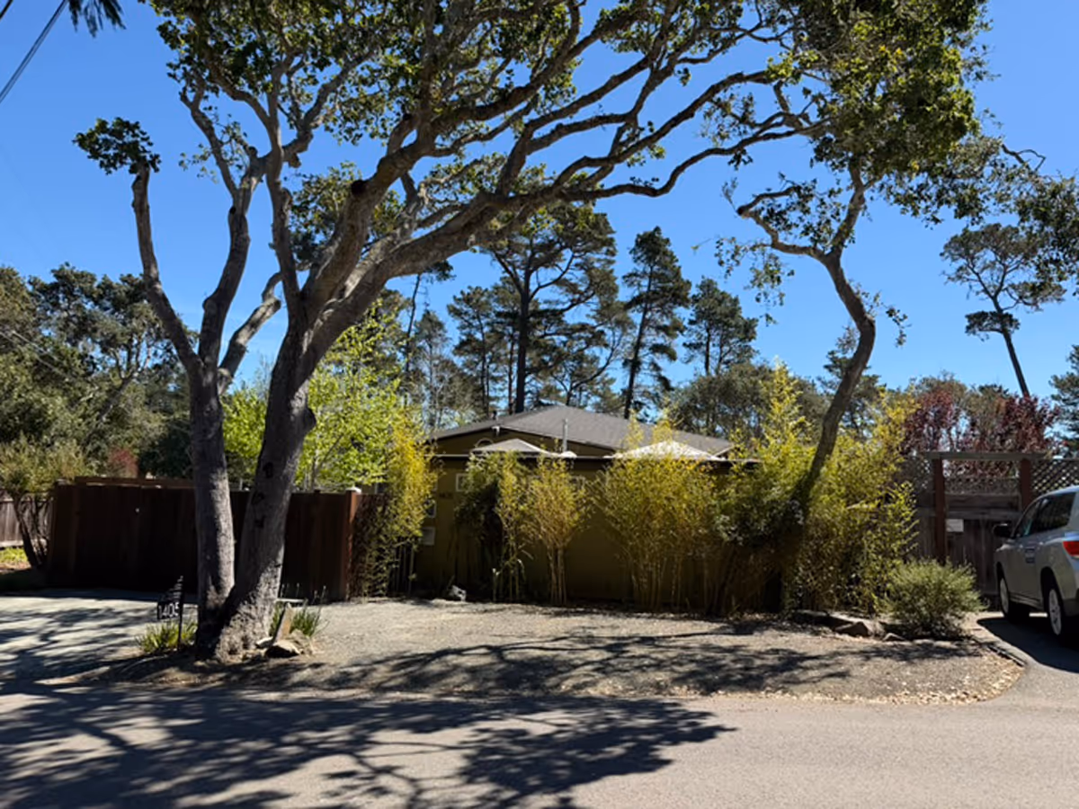 Outdoor view of Cherish Care facility exterior with trees and a parked car.