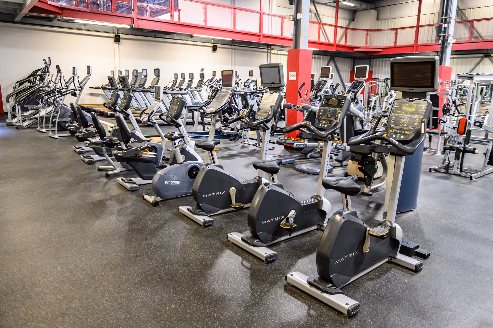 Indoor gym area with numerous treadmills and stationary bikes in a spacious fitness room.