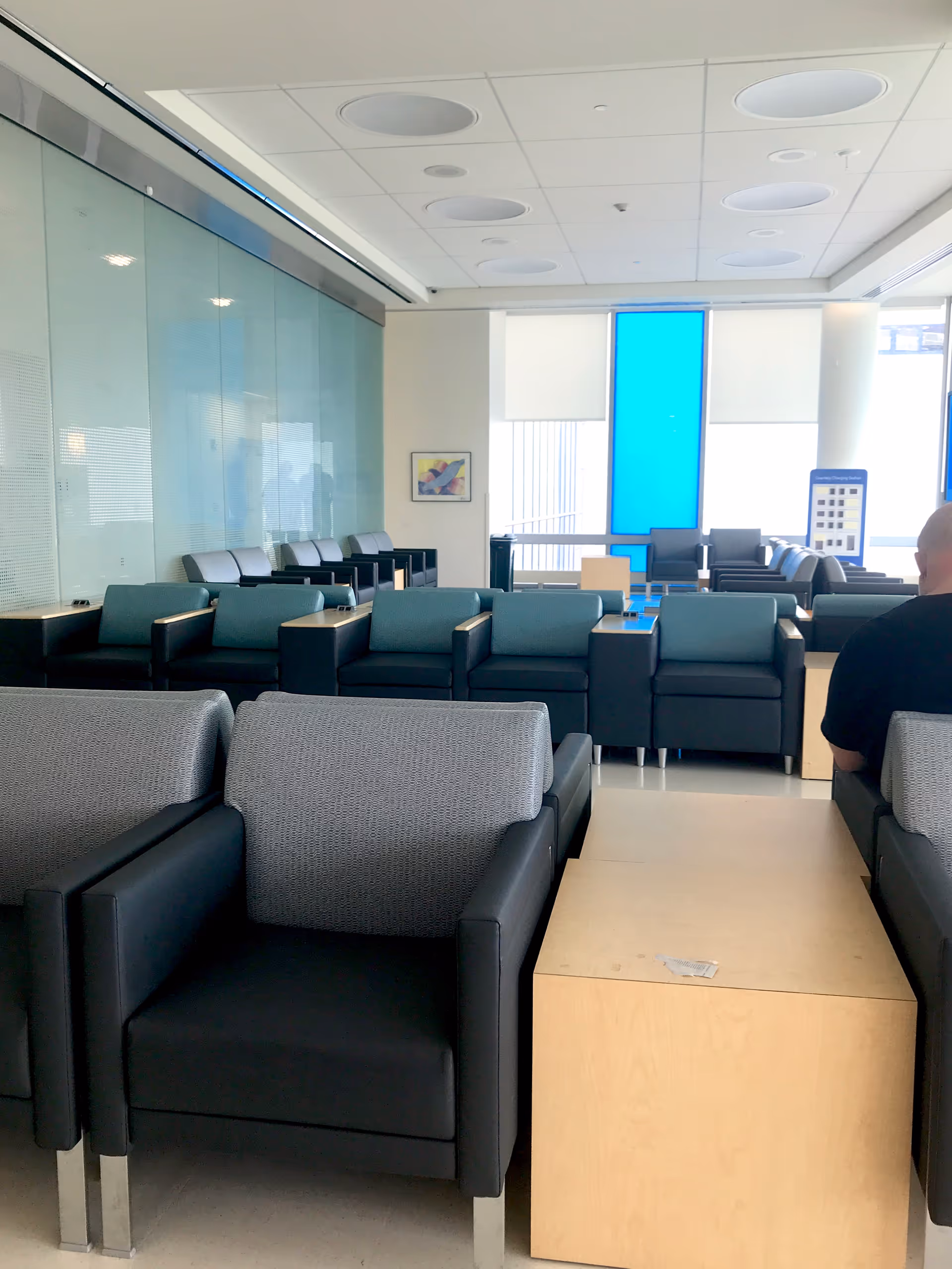 Modern clinic waiting area with blue seating and large windows.