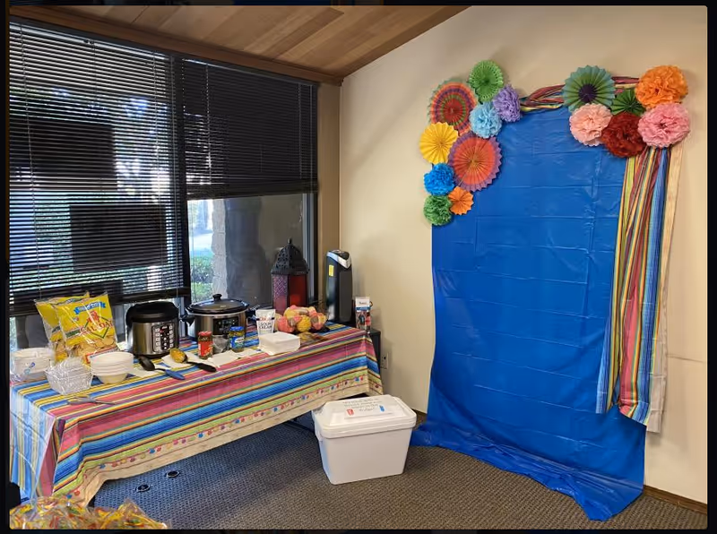 Festively decorated interior room with snack table and blue photo backdrop.