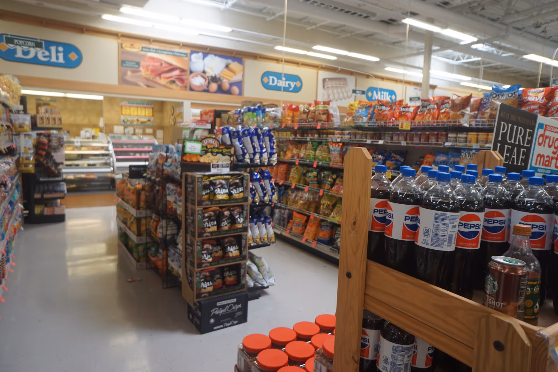 Interior of Discount Drug Mart with snack shelves and soda on display.