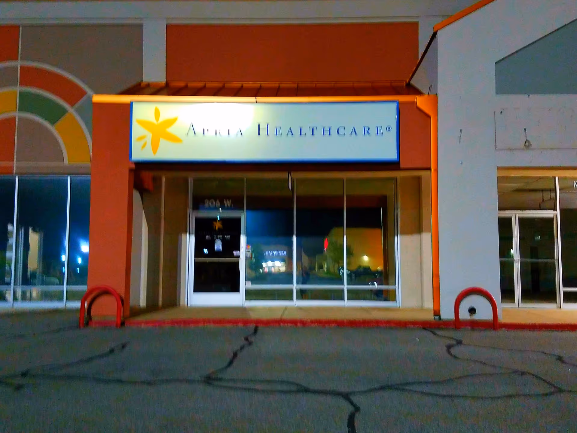 Apria Healthcare storefront with glass doors, illuminated sign, and colorful exterior.