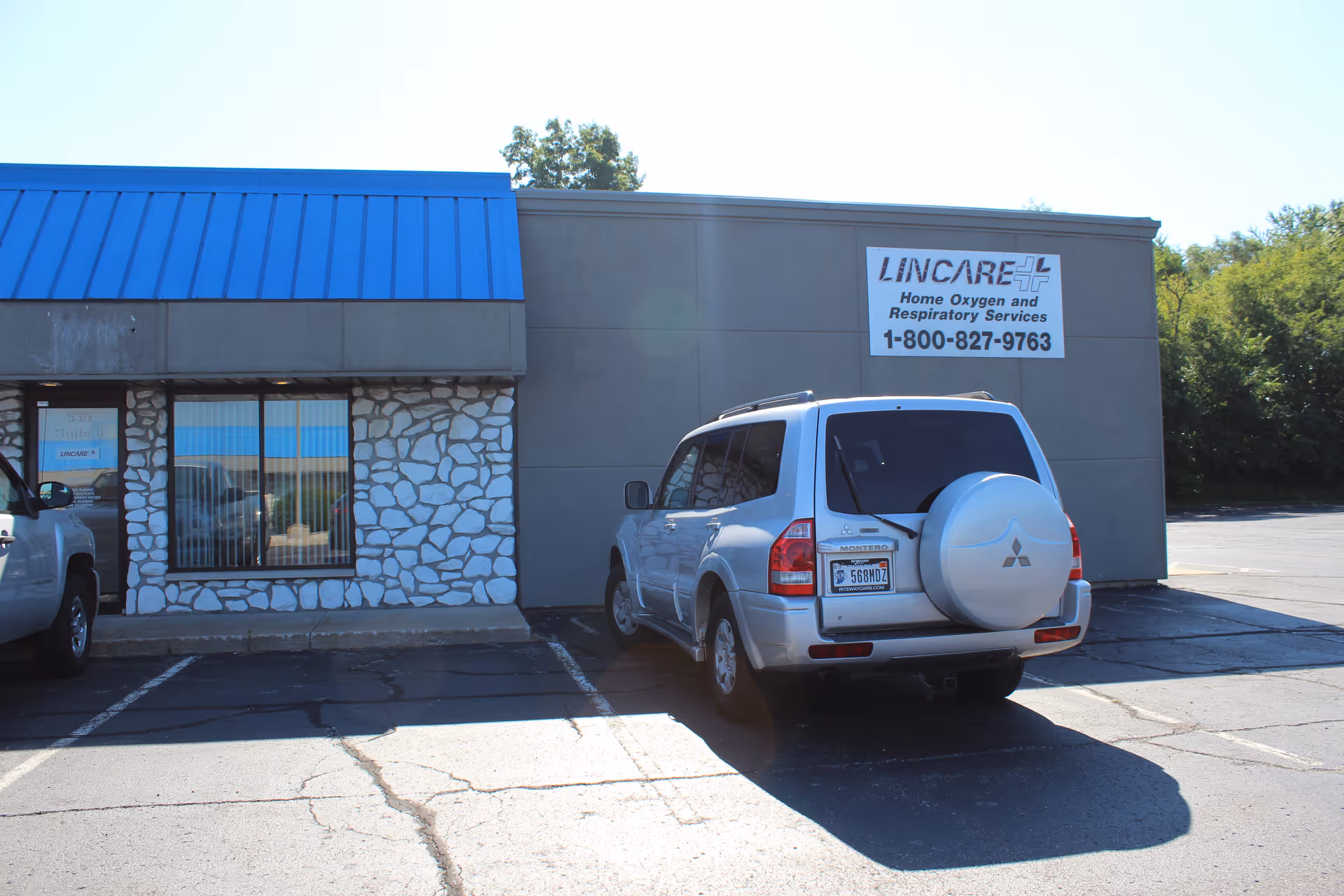 Exterior view of a LINCARE building with a parked white SUV in front.