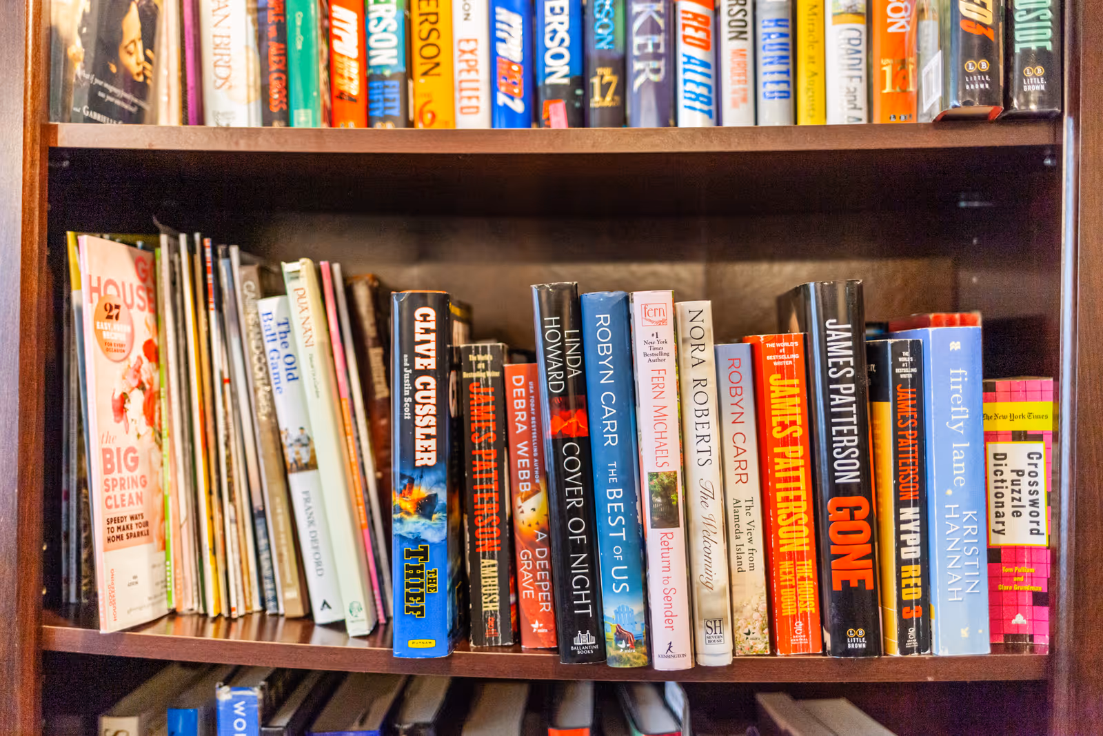 Wooden bookshelf filled with colorful book spines in a library.