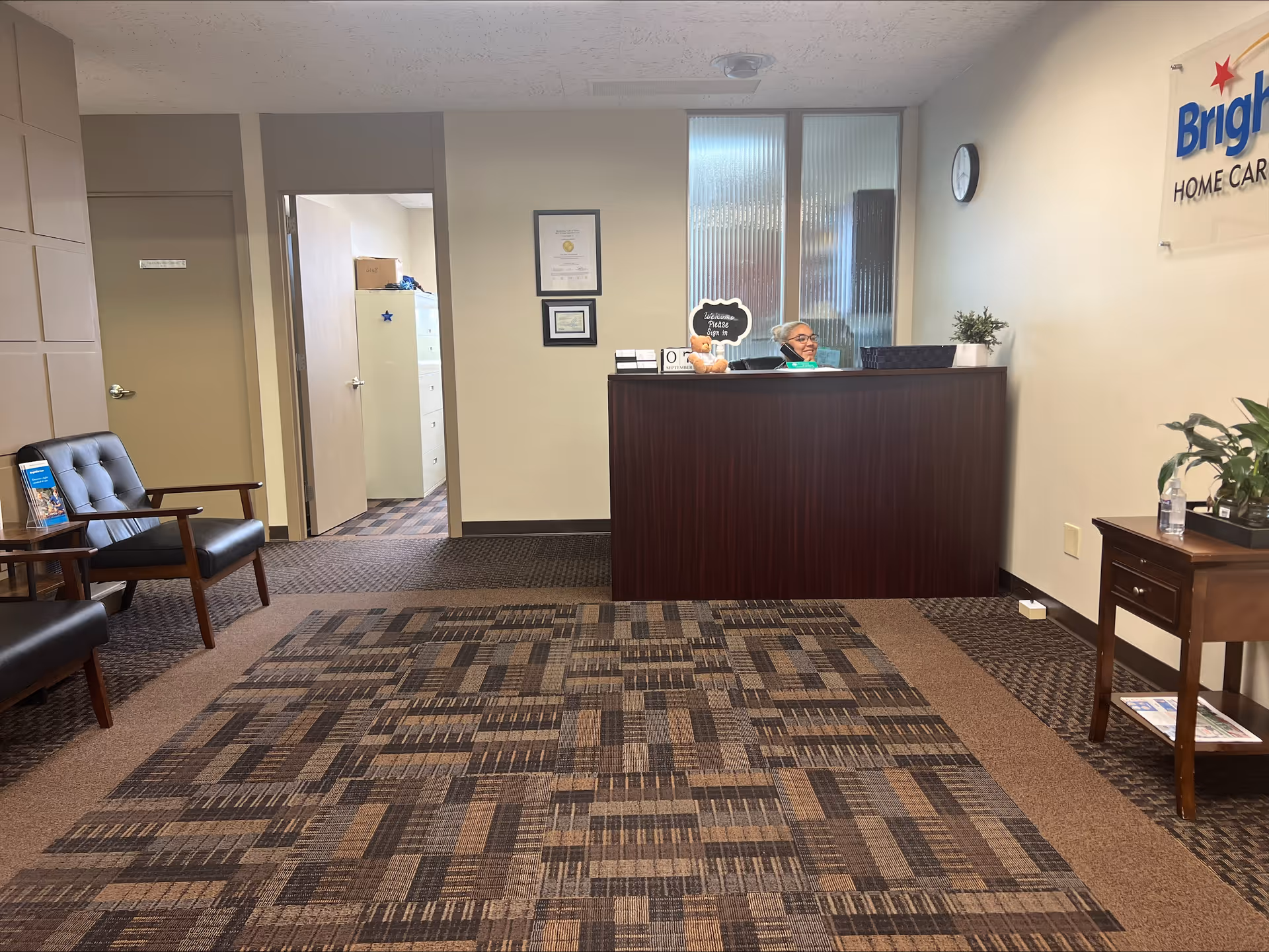 Lobby reception area of BrightStar Care with a dark wood desk and seating.