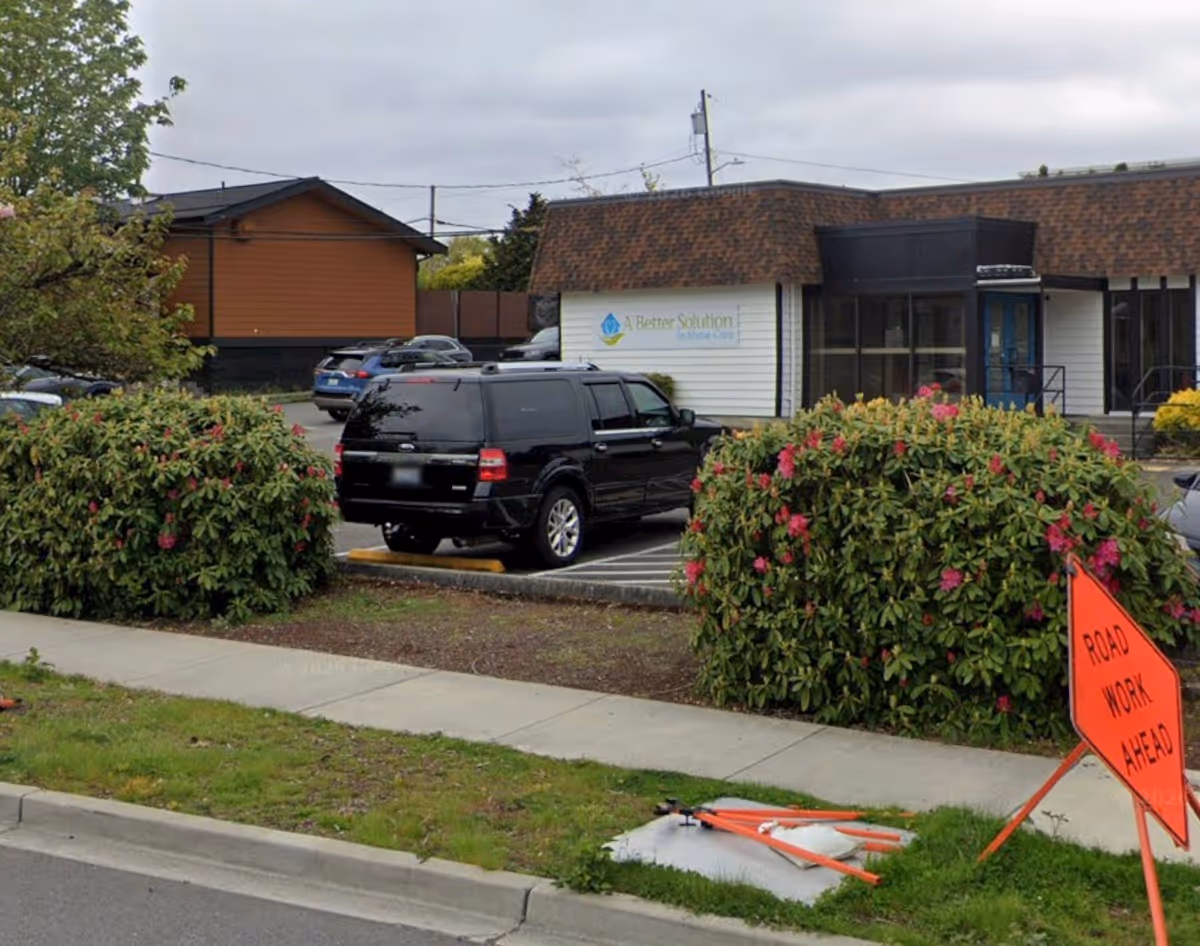 Exterior view of A Better Solution In Home Care facility with parked cars and landscaping.