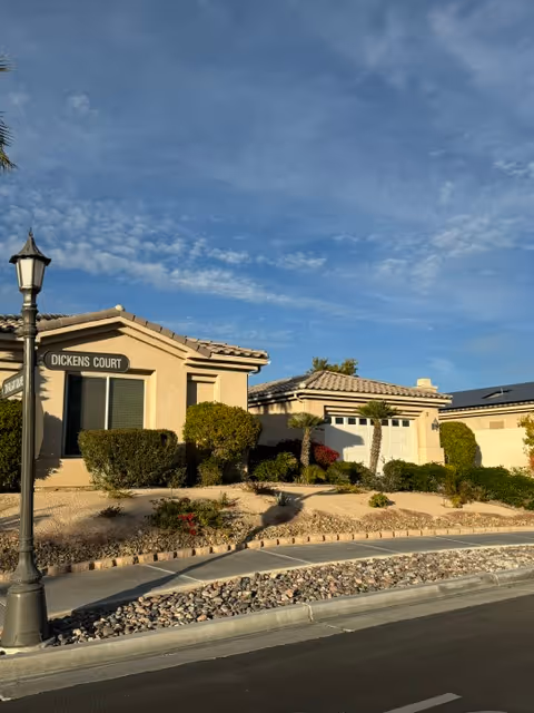 Sunlit single-story beige building labeled Dickens Court with desert landscaping.