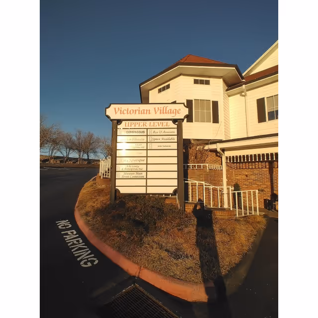 Exterior view of a senior living facility with Victoria Village sign and landscaping.
