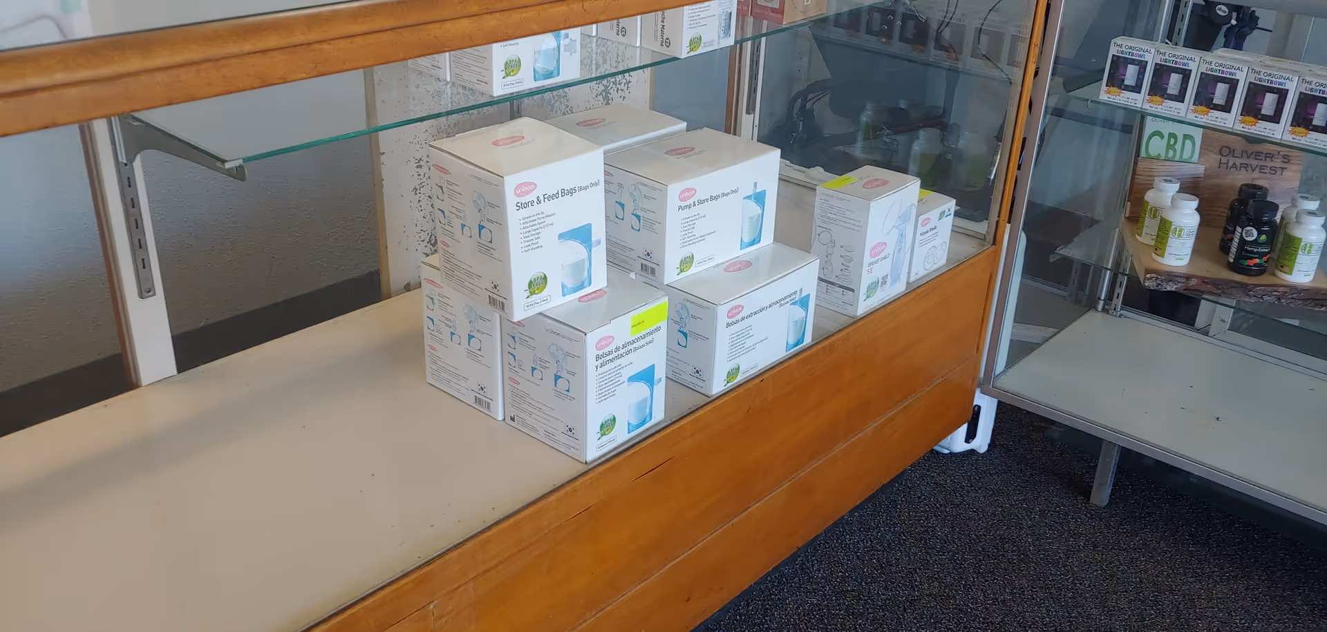 Indoor display counter with stacked medical supply boxes under glass shelves.