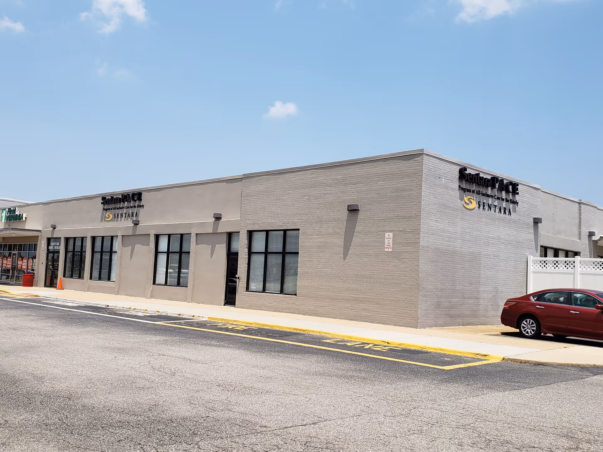 Exterior view of a Sentara PACE facility building with parking lot and blue sky