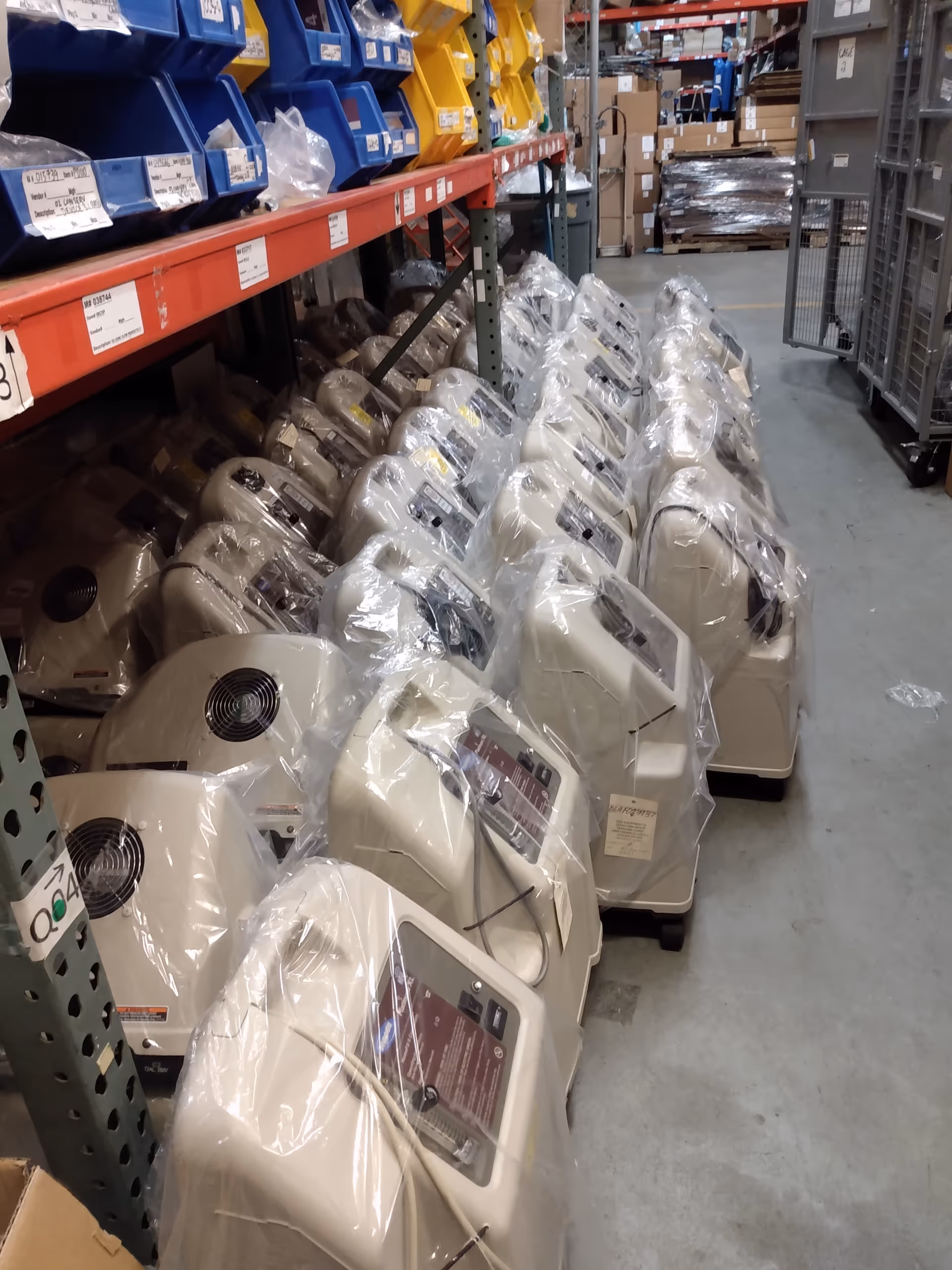 Warehouse-style storage area with wrapped medical devices lined along aisles.