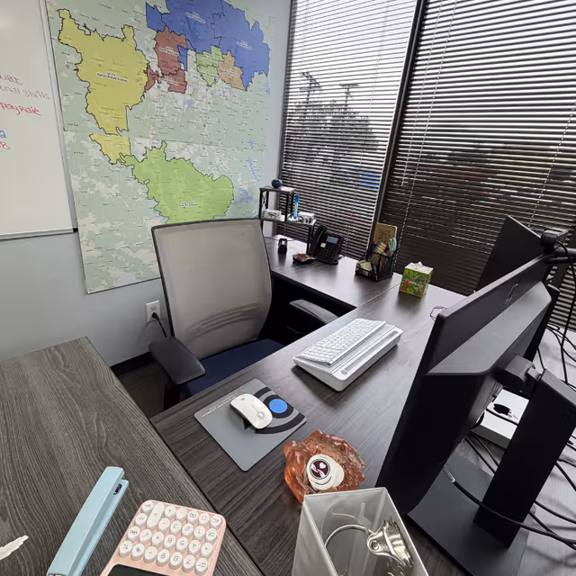 Office desk area in Amada Senior Care with a map on the wall and blinds.