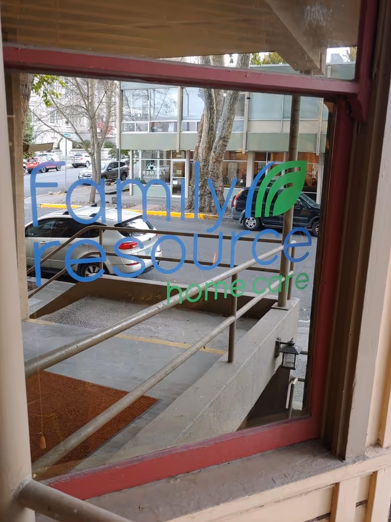 Front window of a building shows Family Resource Home Care logo with street view outside.
