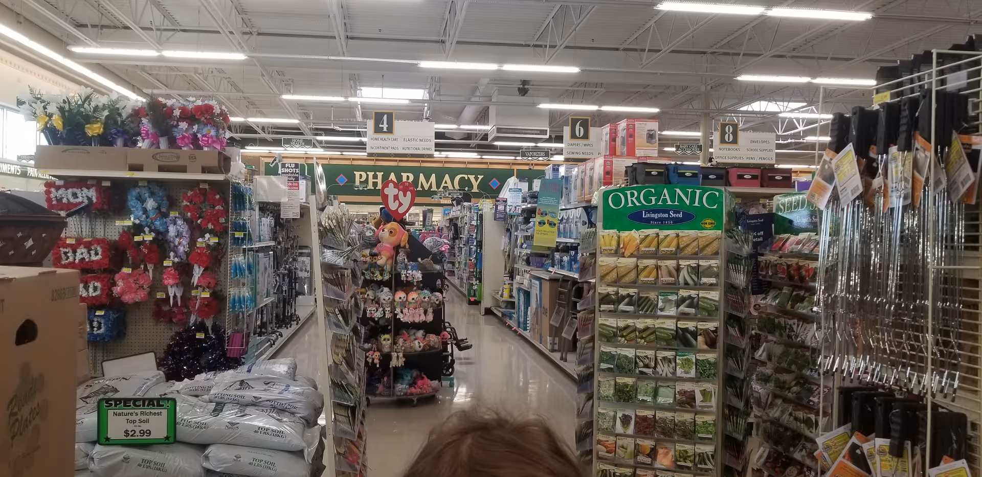 Interior of Discount Drug Mart store with aisles, a pharmacy sign, and merchandise.