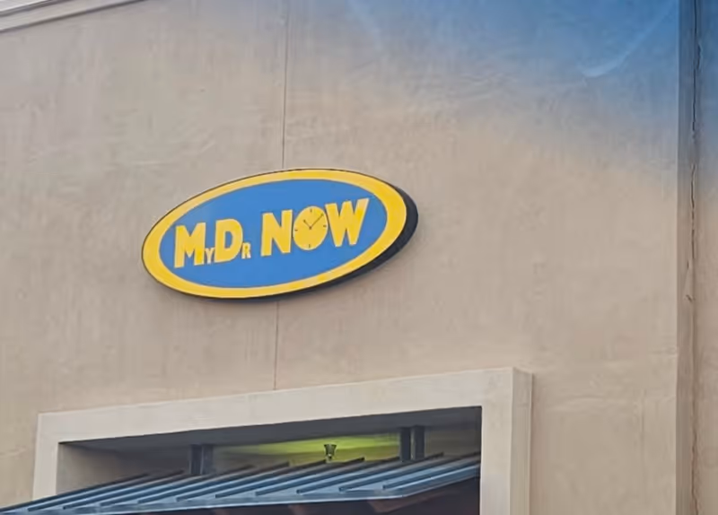 Exterior wall of a senior living facility with a blue and yellow MD NOW sign.