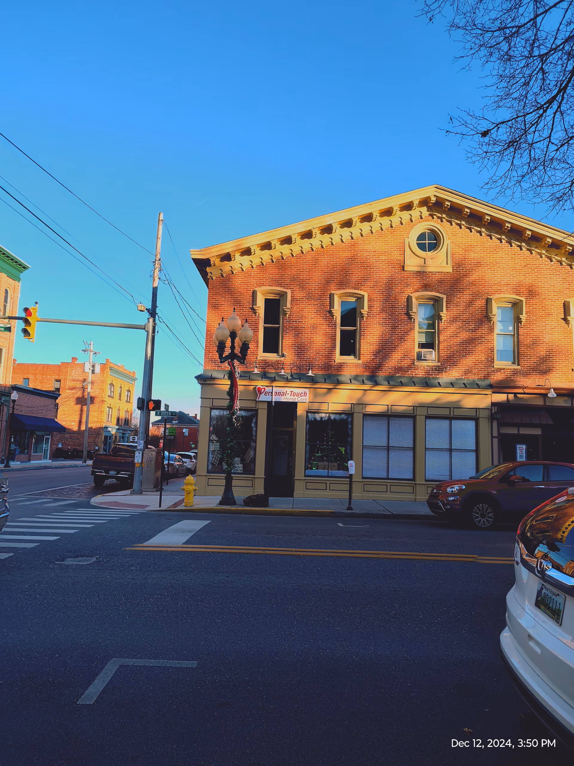 Brick storefront with Personal-Touch Home Care sign on a sunny street corner.