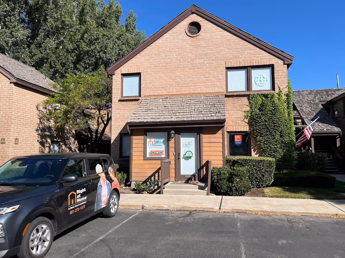 Brick senior living building with a Right at Home van parked at the front entrance.