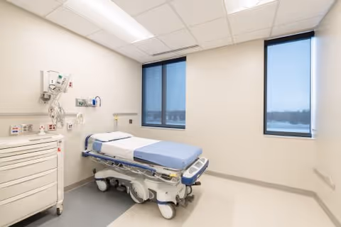 A sterile patient examination room with an adjustable hospital bed and medical equipment.