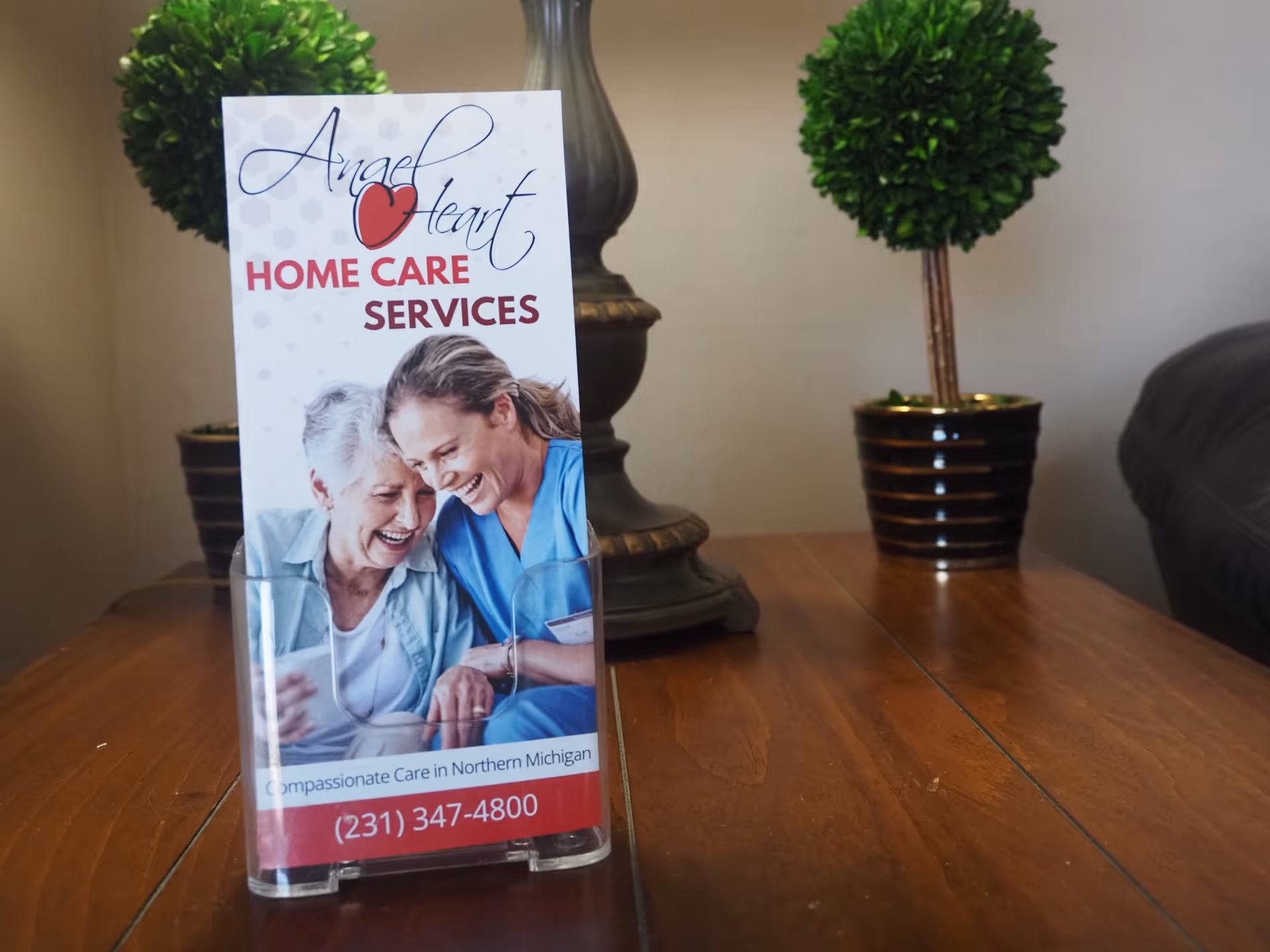 Angel Heart Home Care Services brochure on a wooden table with potted plants