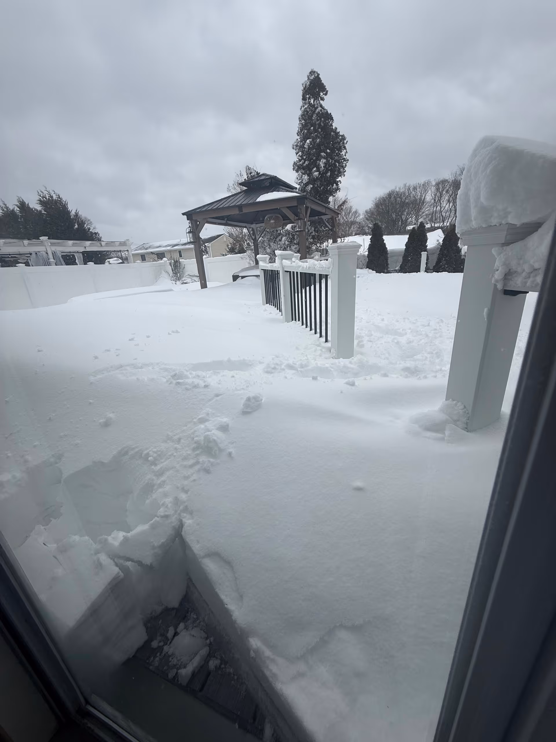 Snow blankets a senior living facility's outdoor courtyard with a gazebo.