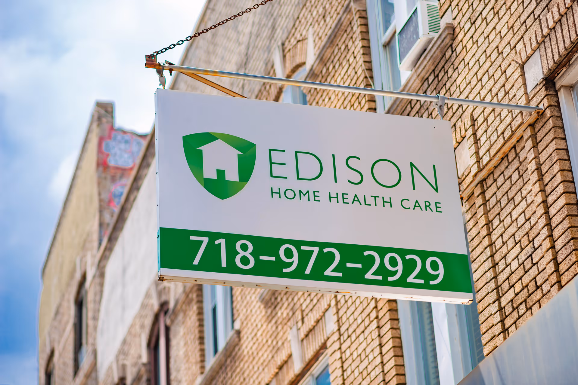 Exterior brick building with a hanging Edison Home Health Care sign and phone number
