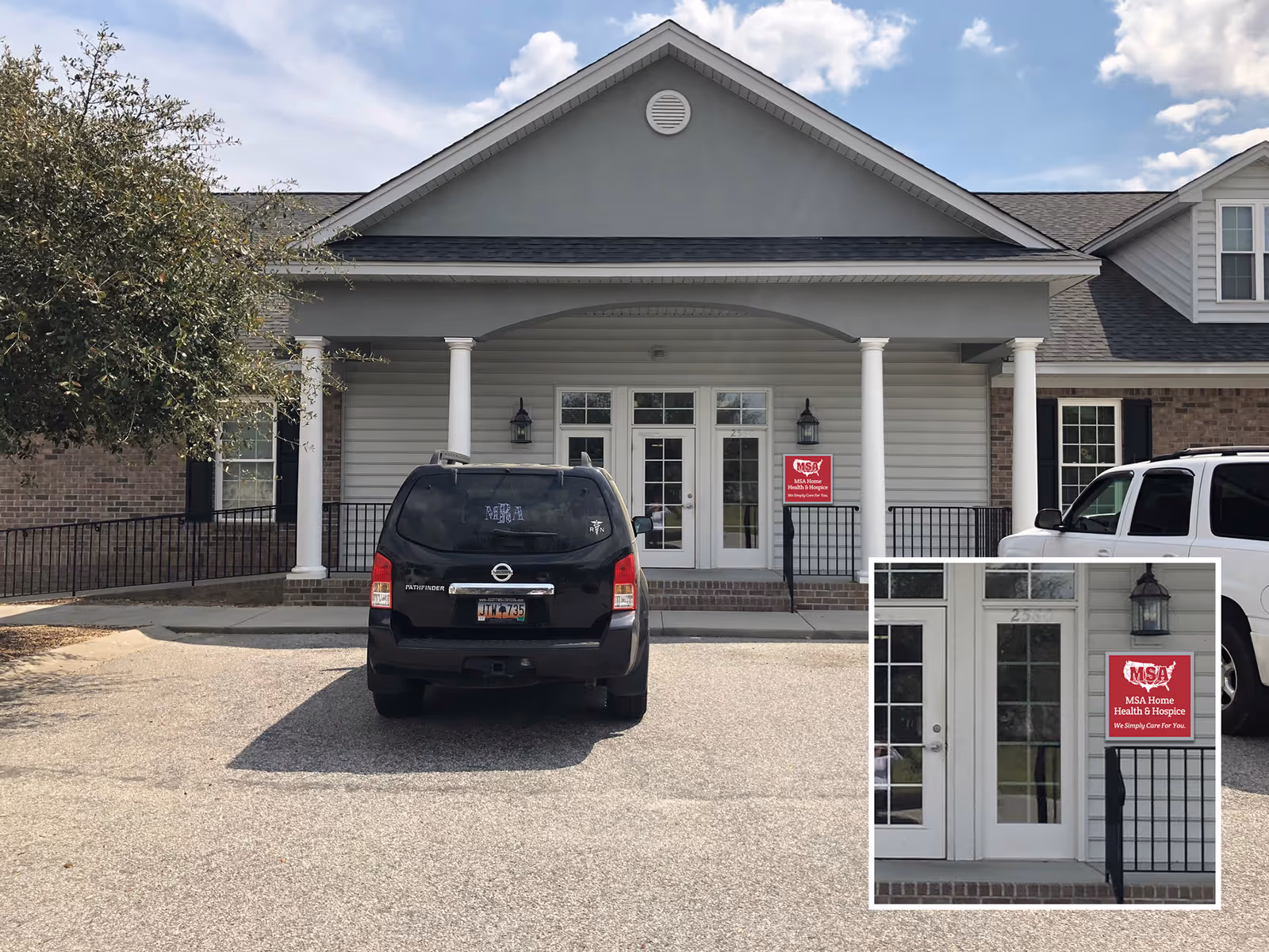 Front view of a gray medical facility with white pillars and a parked SUV.