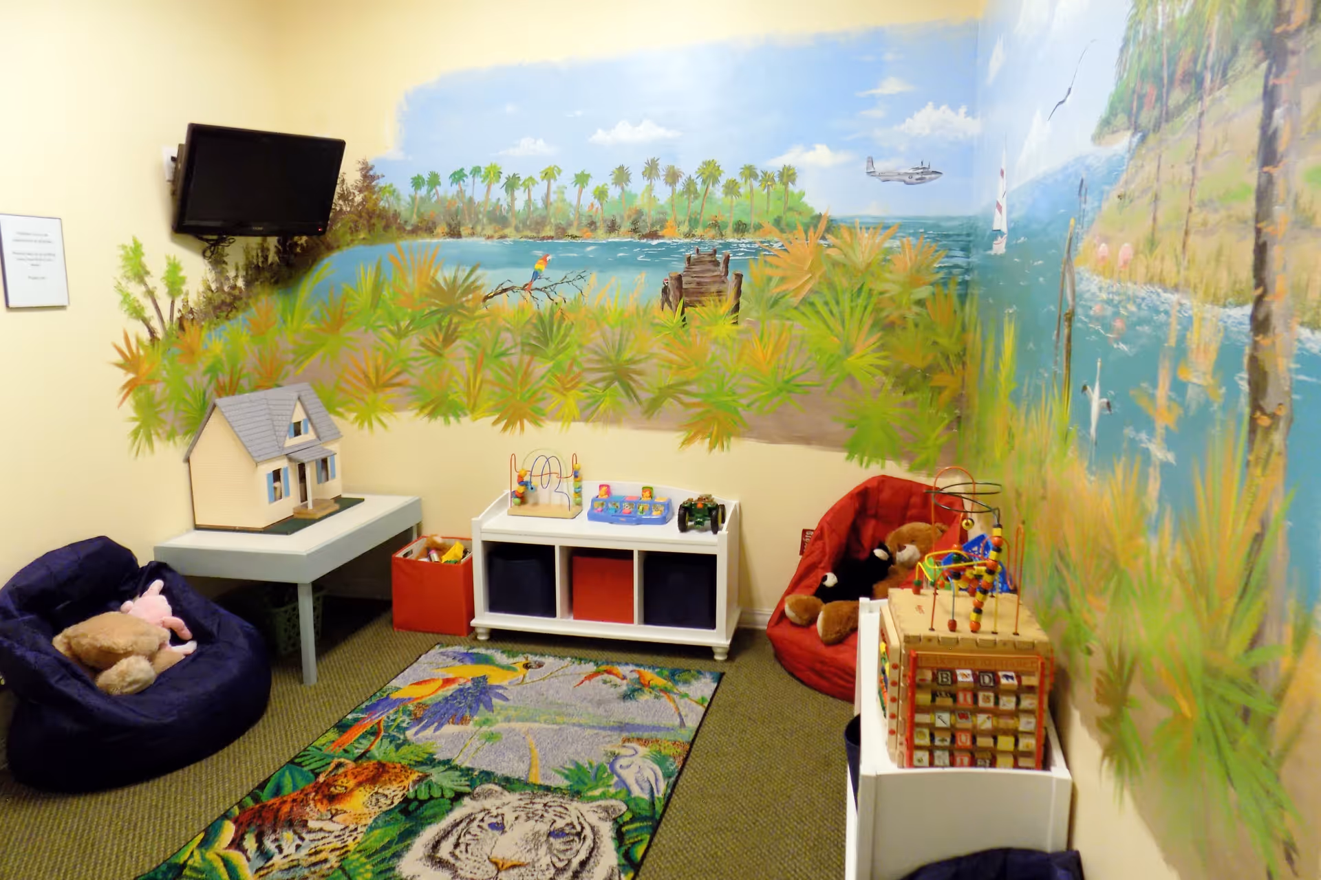 Colorful indoor play area with a mural, toys, and cozy seating.