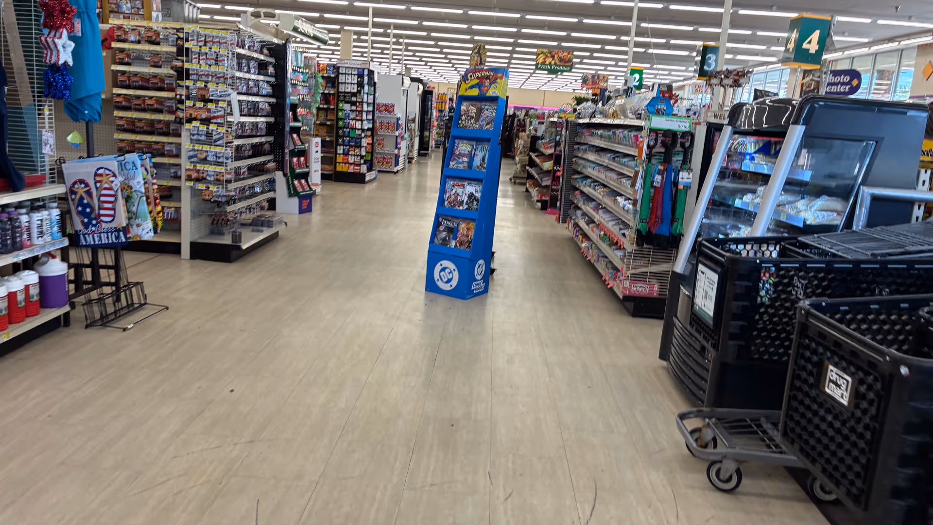 Wide view of a Discount Drug Mart store aisle with shelves and a cart.