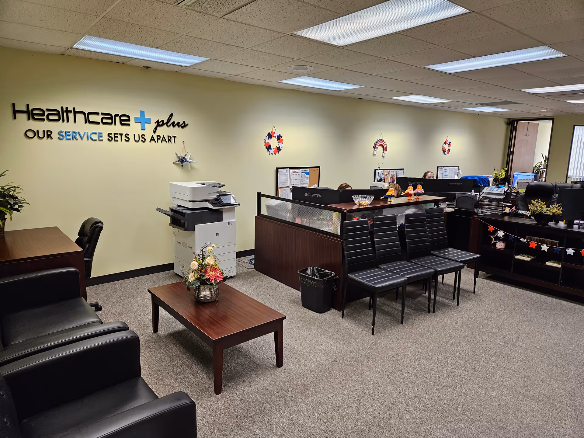 Lobby-style interior of Healthcare Plus Caregivers featuring a reception desk and seating.
