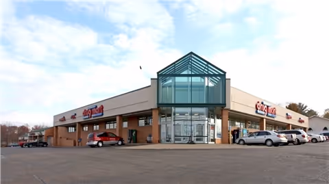 Exterior view of Discount Drug Mart storefront with a glass entrance and parking lot.