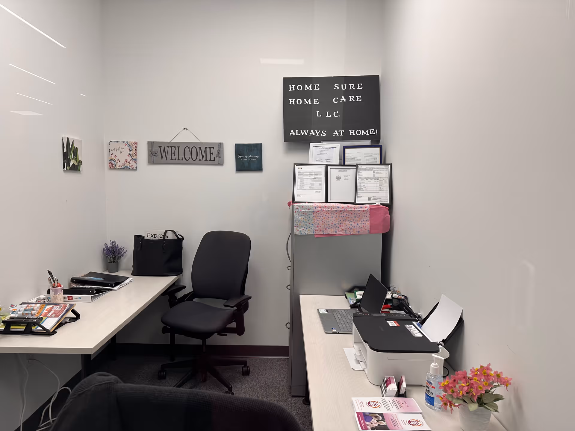 Small office space inside Home Sure Home Care New Brunswick with desks, chairs, and printer.