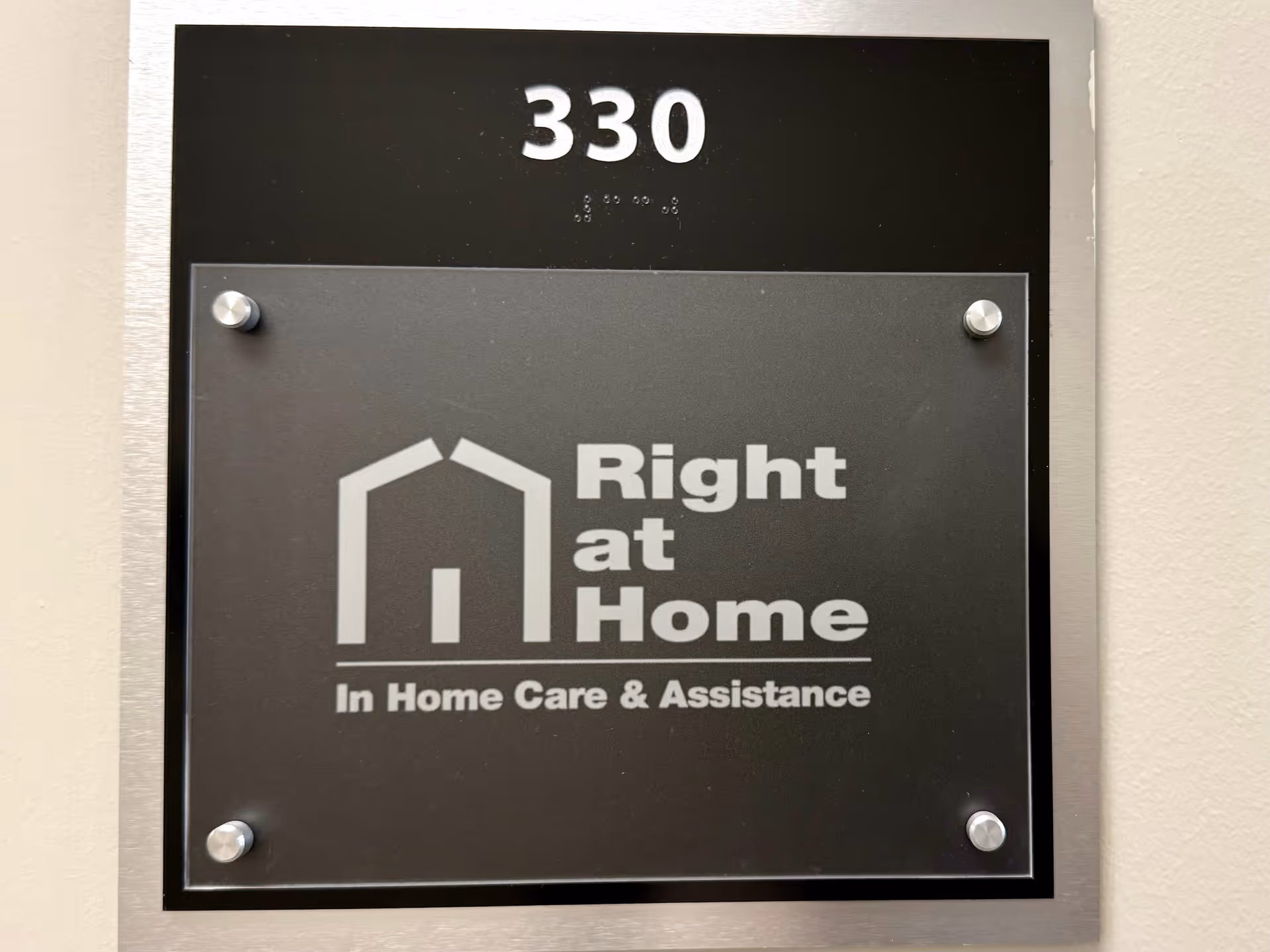 Sign plaque mounted on wall shows Right at Home logo and room number 330.