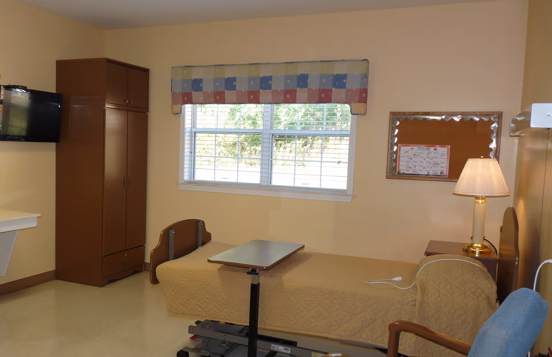 Resident bedroom with single bed, wardrobe, desk, window, and wall-mounted TV.