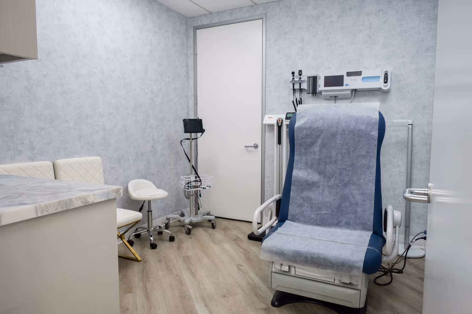 Exam room in a senior living facility with medical chair and monitoring equipment.