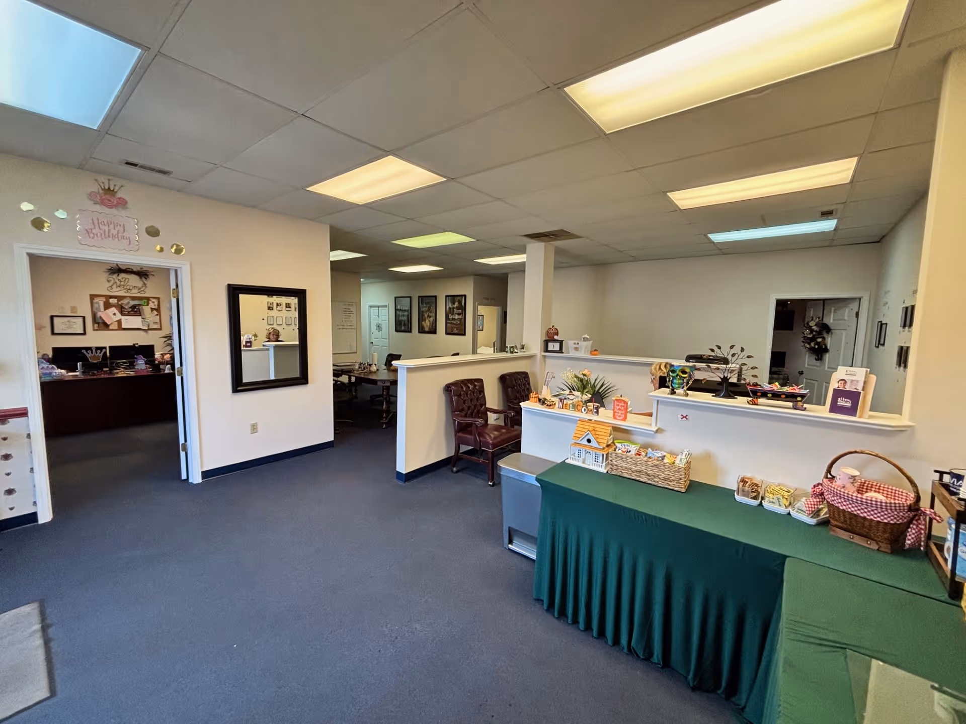 Interior reception area in a senior facility with front desk, tables, and decorations.