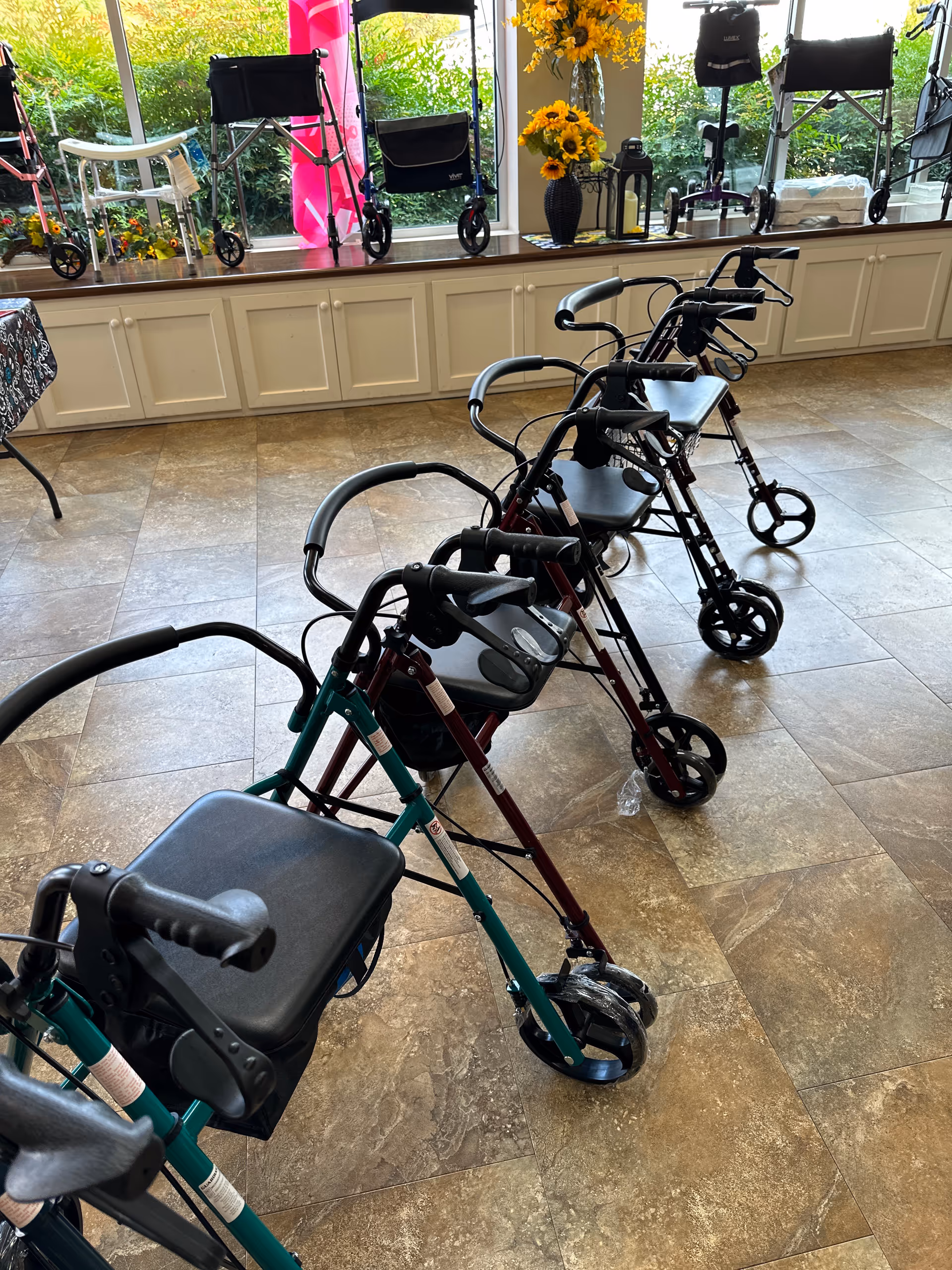 Interior lobby with several walkers lined up by a windowed display.