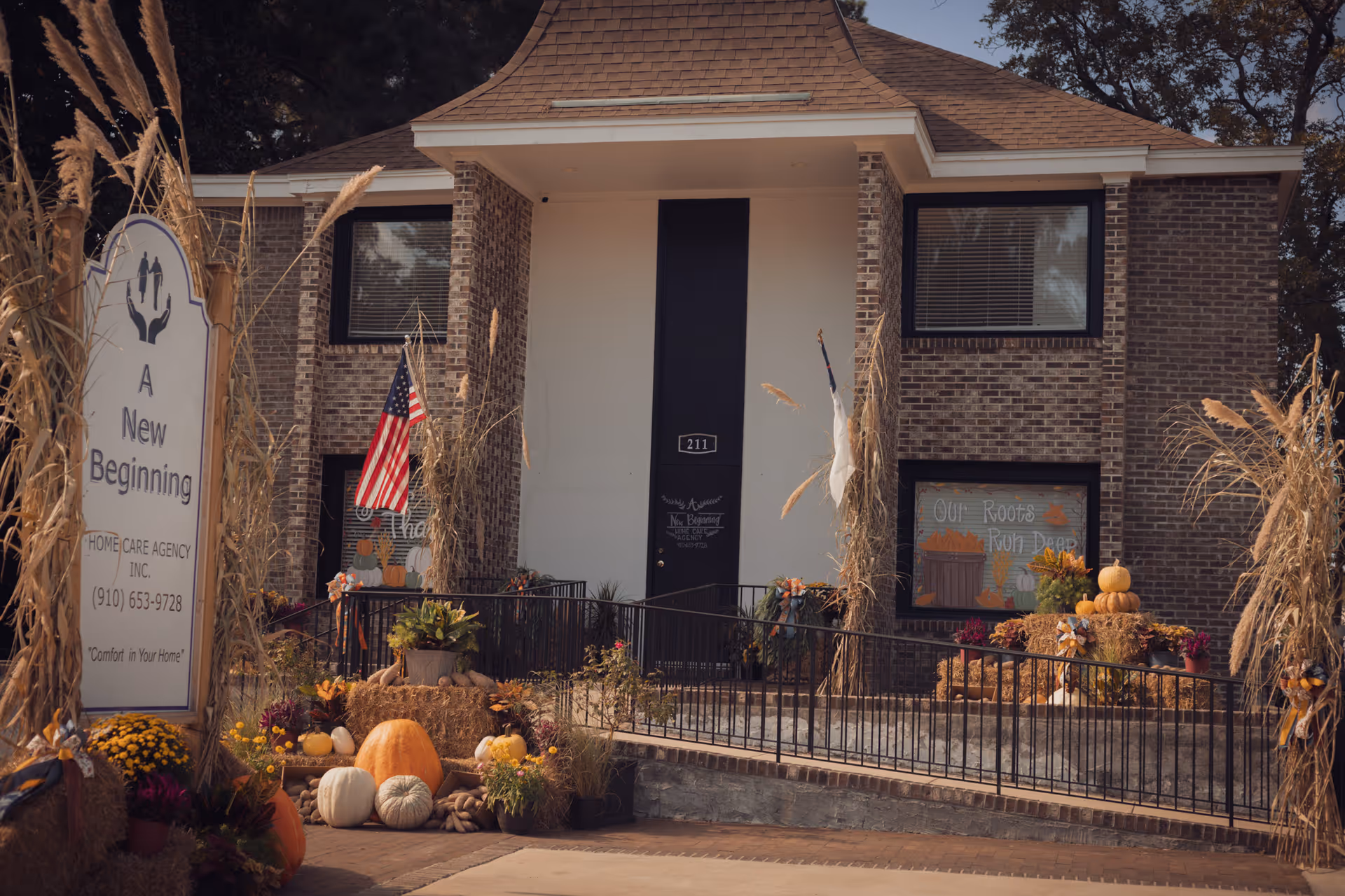 The brick building front of A New Beginning Home Care Agency with fall decorations and pumpkins.